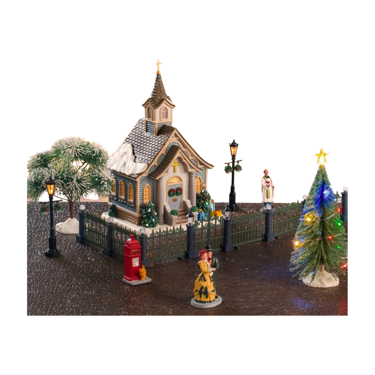 Lemax 18-piece Christmas village set displayed as a scene with lit church, figurines, lamp posts, trees, iron fencing, and red mail box