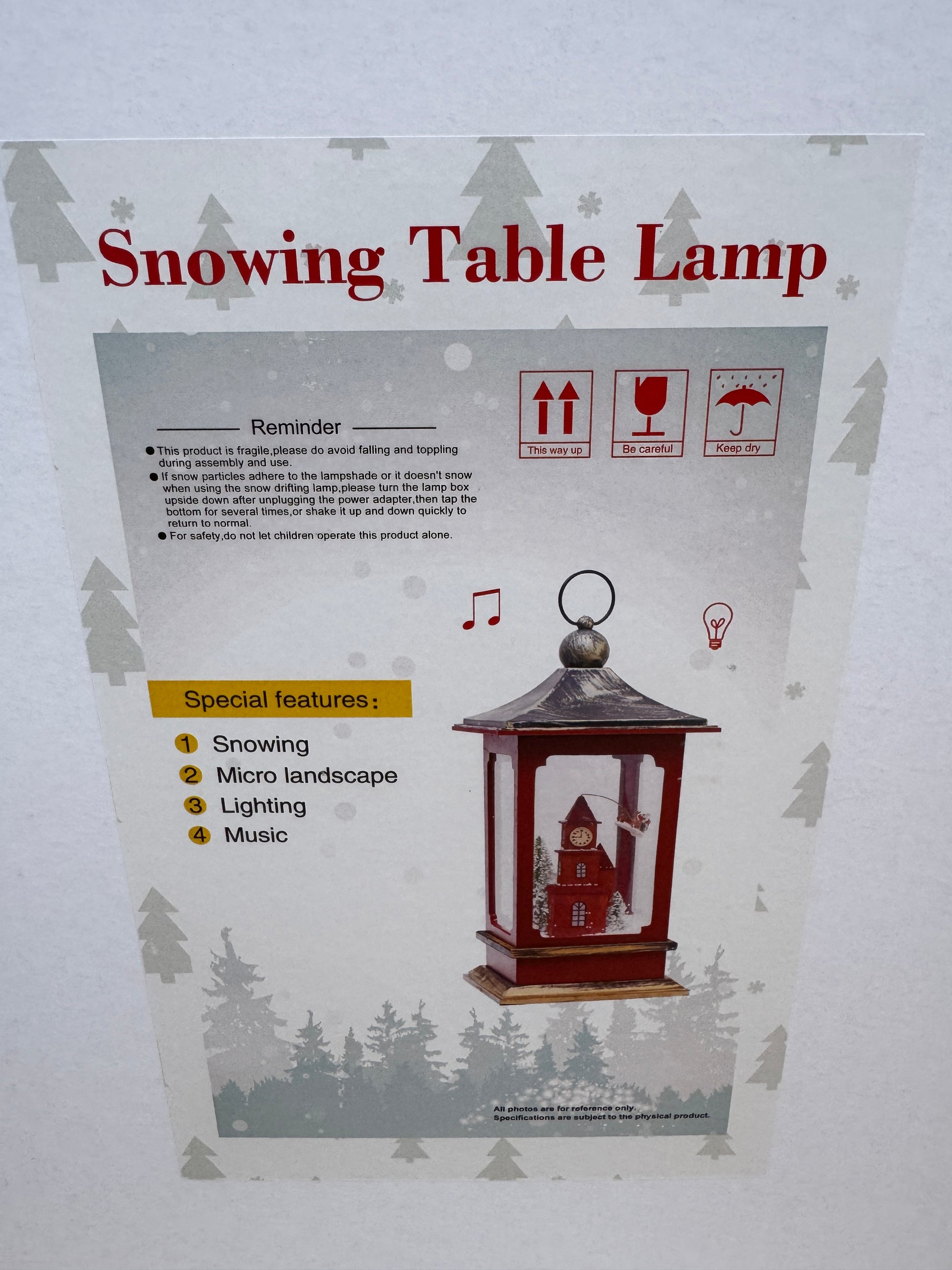 Red lantern featuring a light-up gingerbread house scene with swirling snow and LED illumination