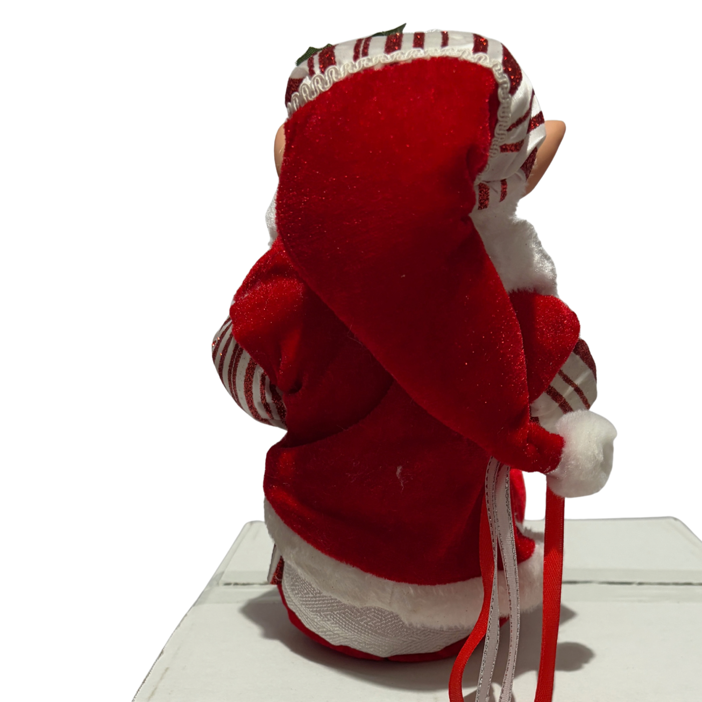 Sitting Christmas elf in red-and-white striped jacket and hat with white trim and red boots