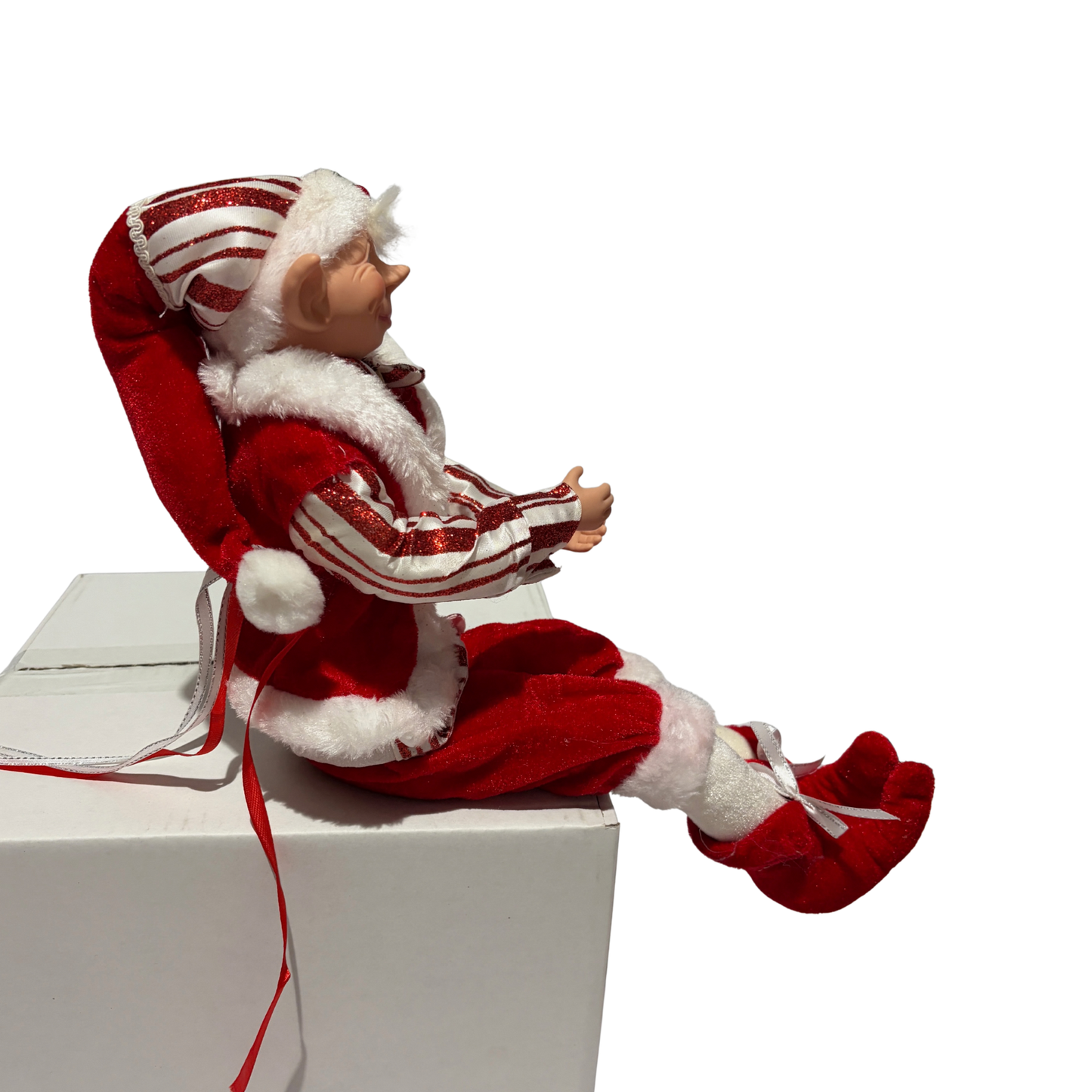 Sitting Christmas elf in red-and-white striped jacket and hat with white trim and red boots