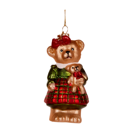 Glass teddy bear decoration wearing a green top and red checkered skirt, holding a small teddy bear with a red bow