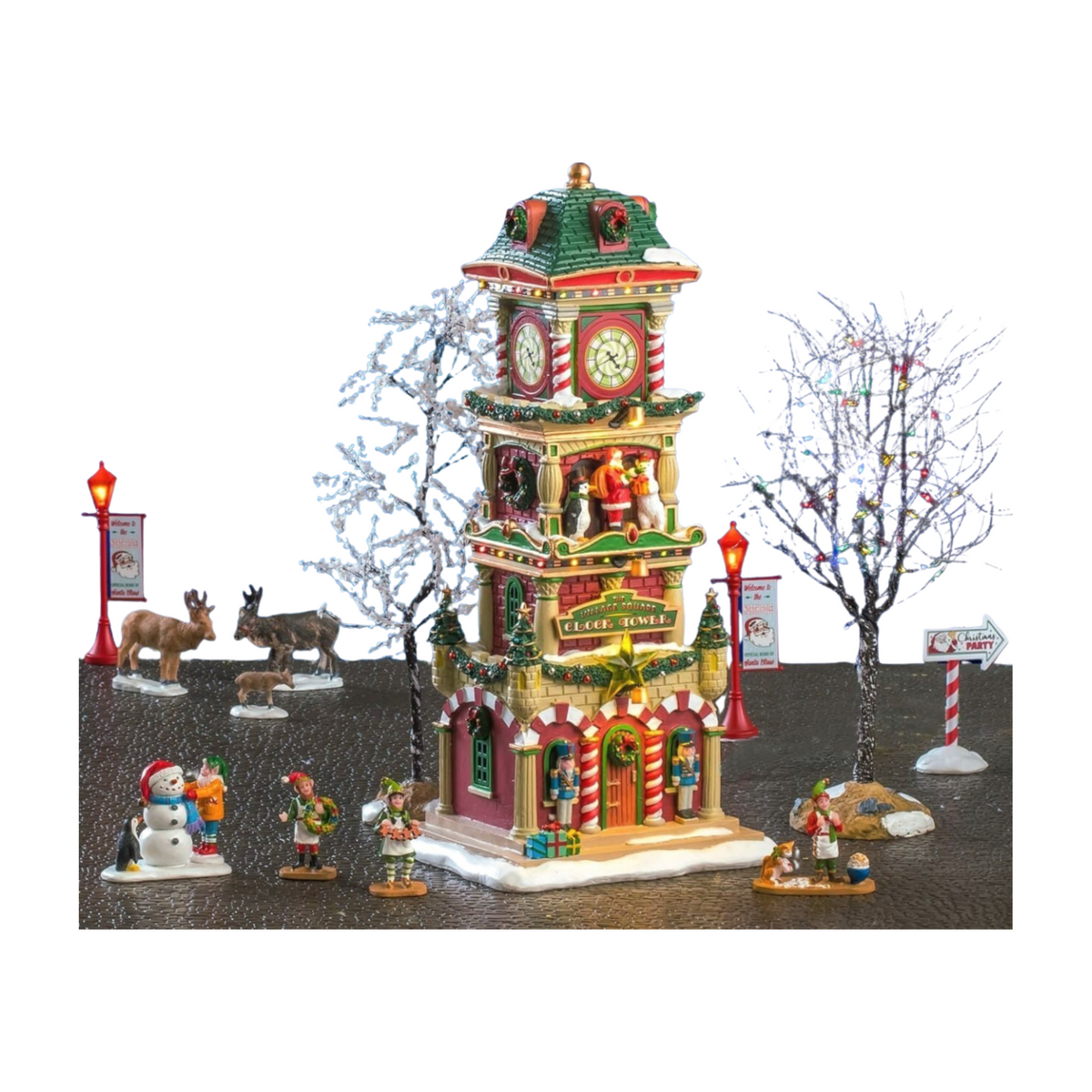 Lemax 15-piece Christmas village scene with lit clock tower, bare decorated trees, elf figurines, reindeer, snowman, lamp posts, and direction signs