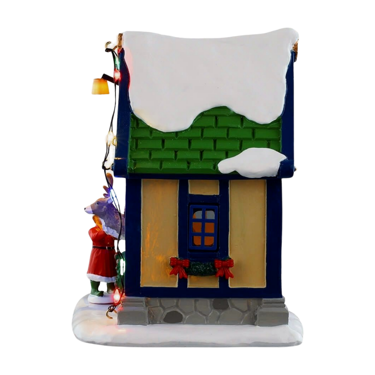 Left view of Vixen's reindeer stable village building with blue and cream facade, lit window, red bow window box, and reindeer figurine