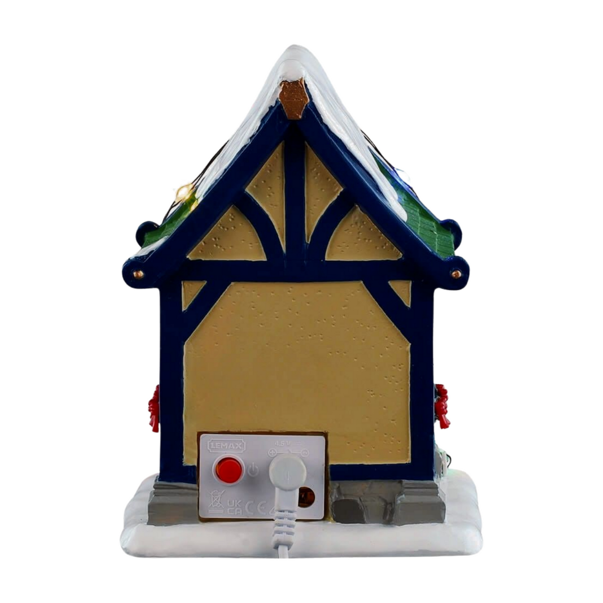Rear of Vixen's reindeer stable village building with blue timber-framed gable, green roof section, and power connector at base