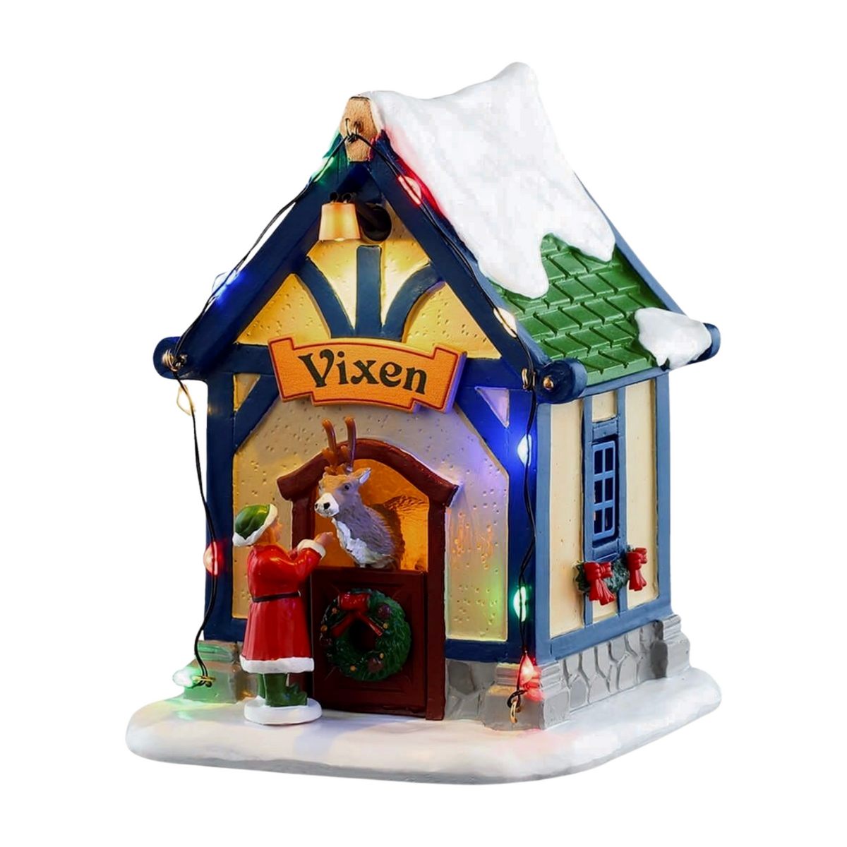 Front of Vixen's reindeer stable village building with blue and cream facade, lit arched doorway, Vixen sign, reindeer, and elf figurine