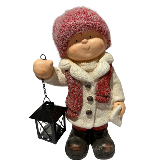 Winter boy figurine in a white coat and red hat holding a black lantern