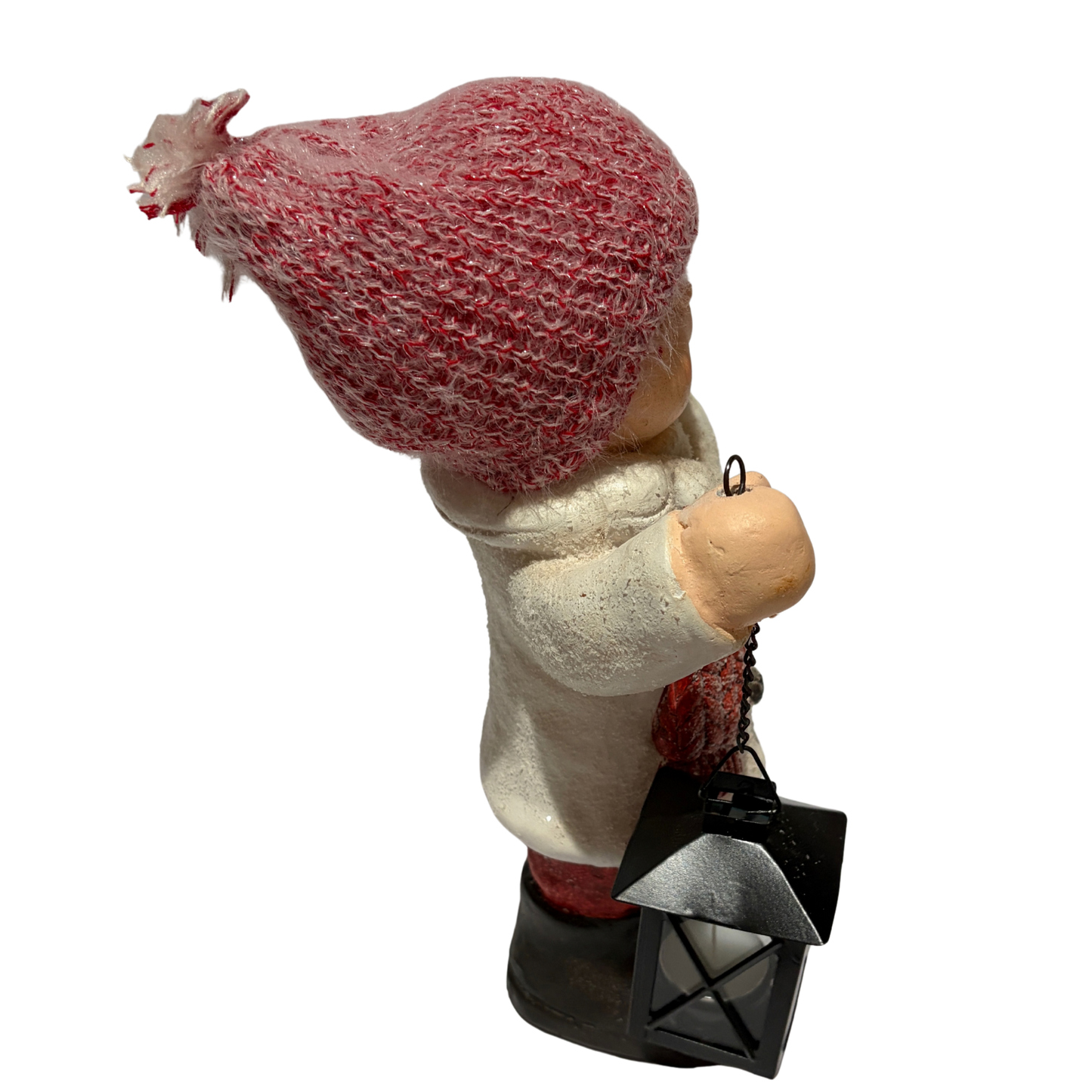 Winter boy figurine in a white coat and red hat holding a black lantern