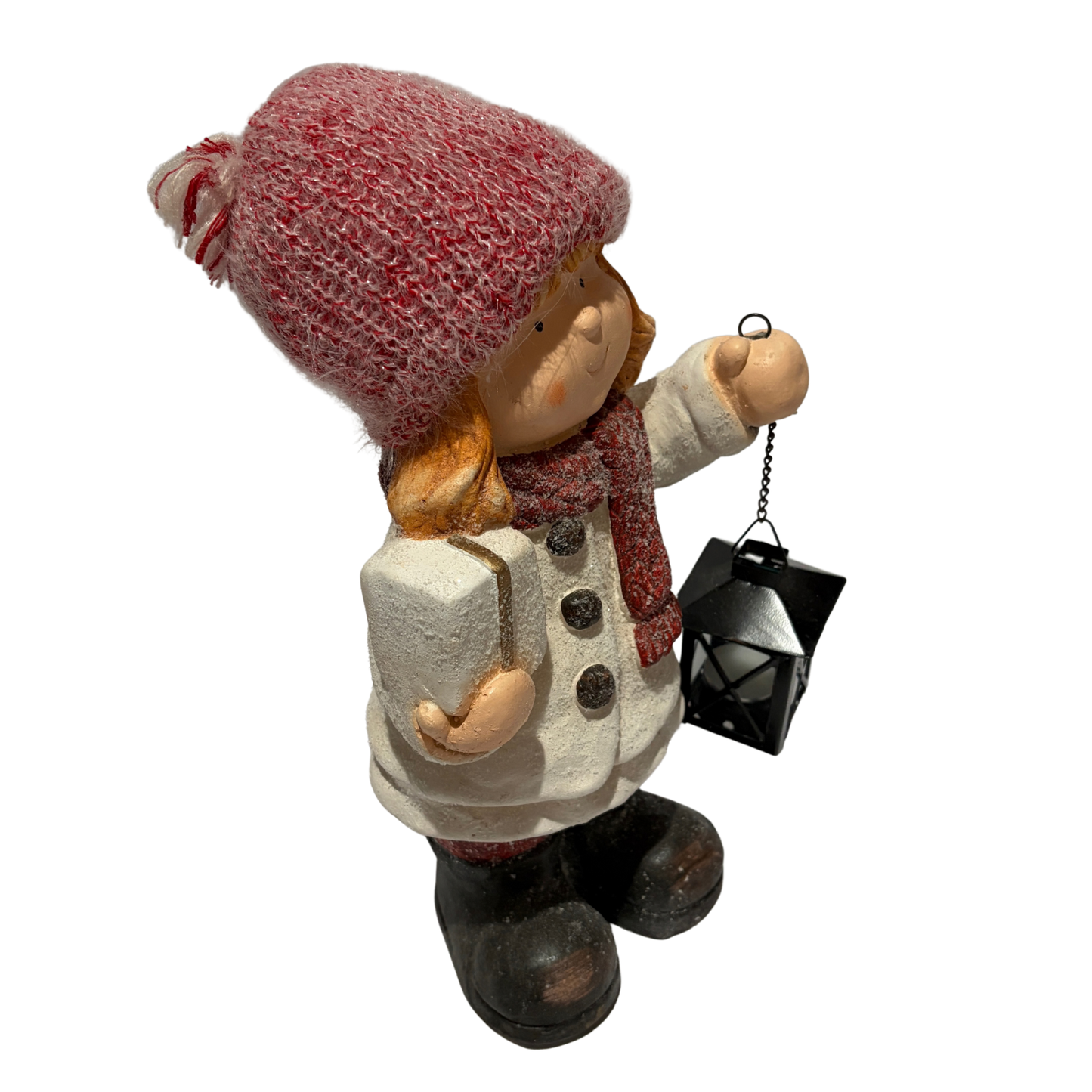 Winter girl figurine in a white coat and red hat holding a black lantern