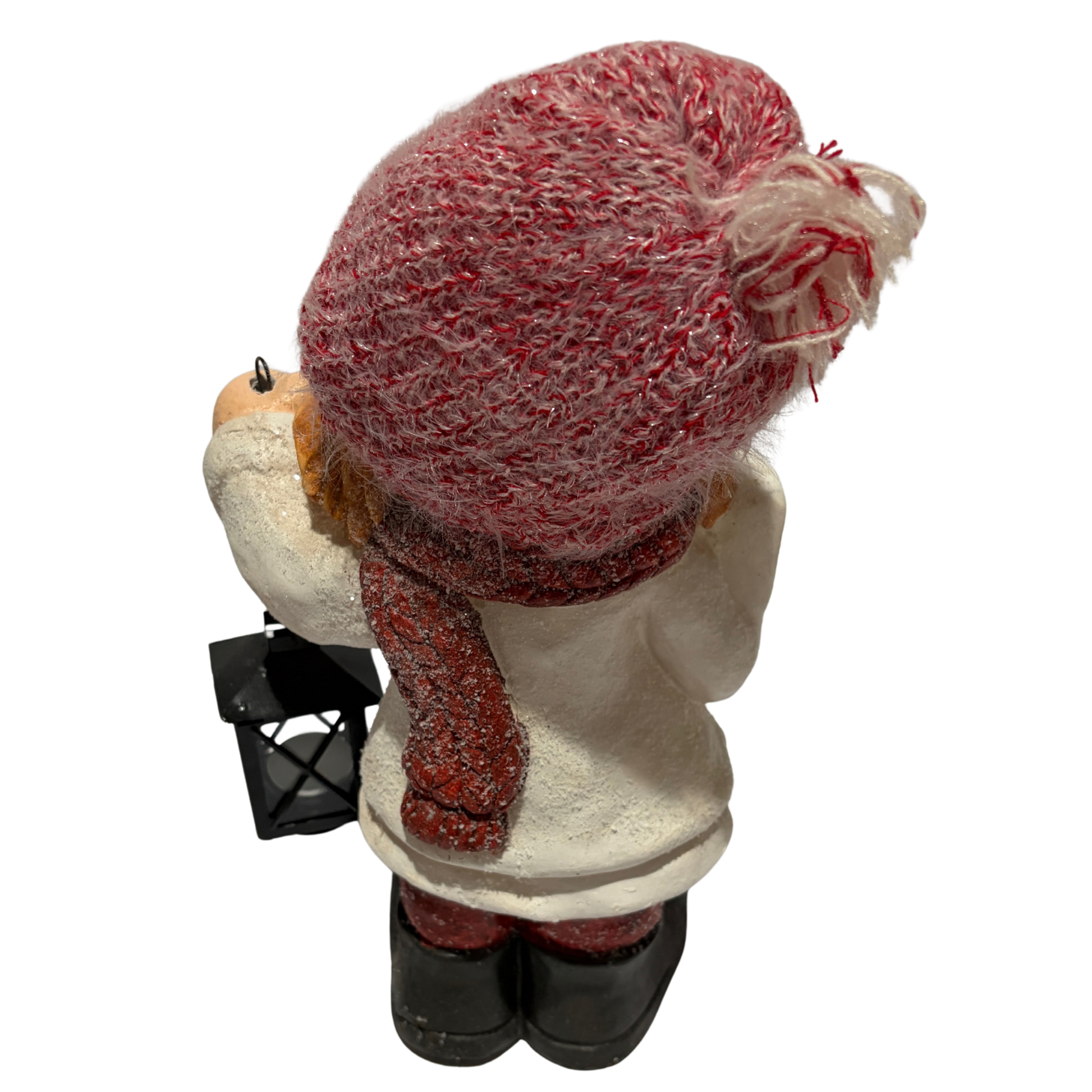 Winter girl figurine in a white coat and red hat holding a black lantern