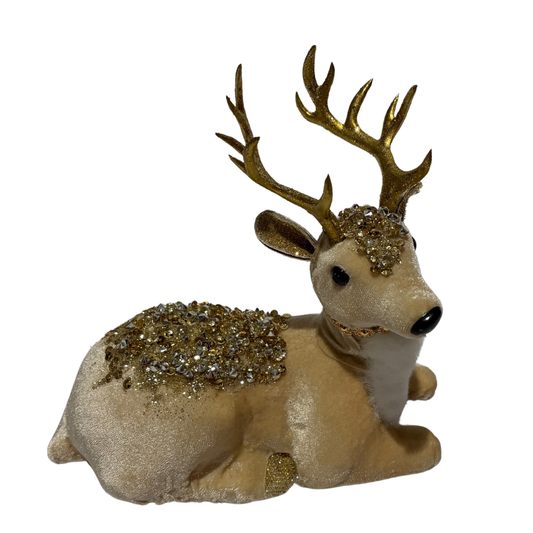 White reindeer figurine lying down with gold antlers and sparkling gold embellishments